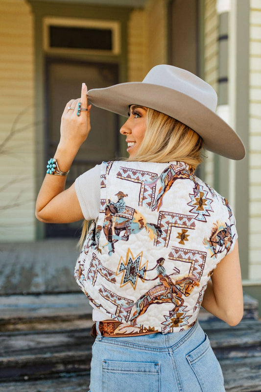 Ida Mae Cropped Tara Vest has a Southwestern and Bucking Horse pattern is quilted and lined. The model shoes the backside of the vest